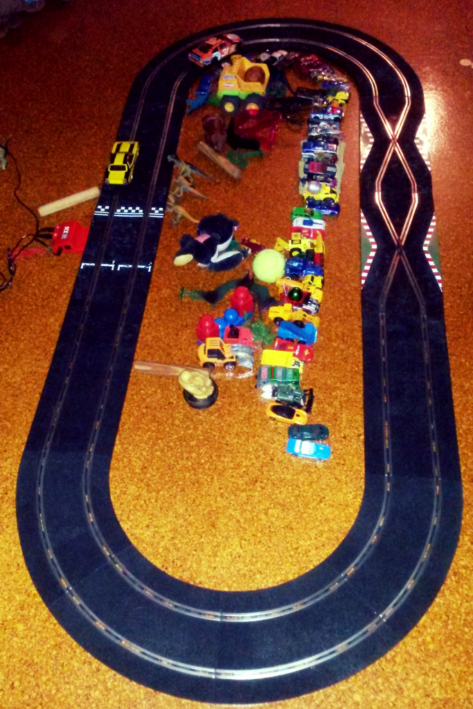 The forbidden slot car track, complete with legions of fans who have gathered to watch the big race.
